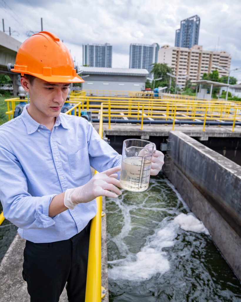 engineer-take-water-from-wastewater-treatment-pond-2023-11-27-04-59-26-utc